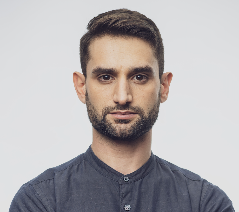 Benjamin Fischer with a navy blue shirt in front of a white background
