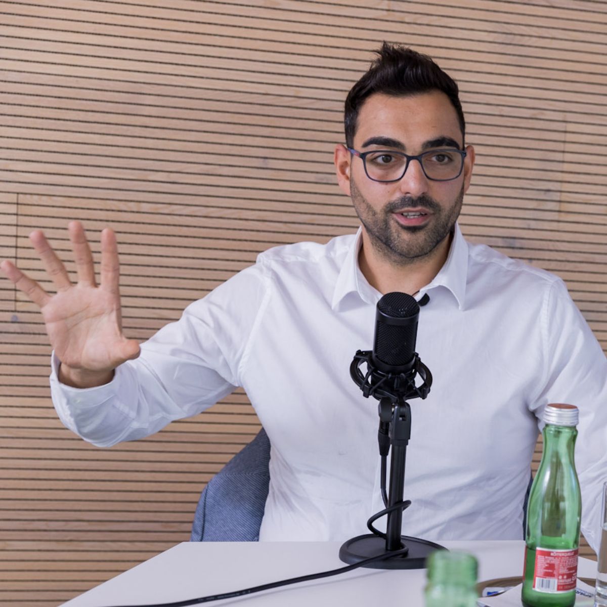 Engin Eser, Co-Founder der Event Punks GmbH, sitzt vor einem Mikrofon